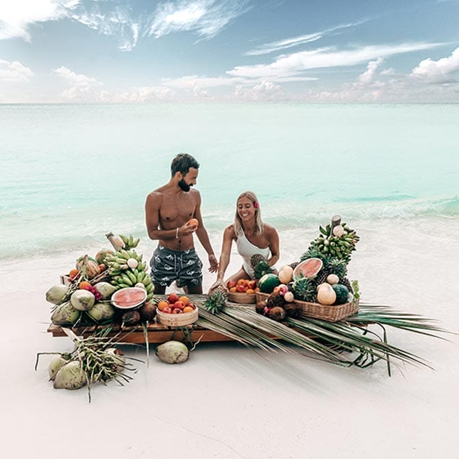 A couple enjoying exotic fruits at the tropical lagoon