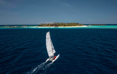 Sailing boat sailing towards the island