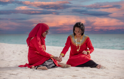 Two women playing ohvalhu gondi at the beach