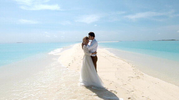 A romantic moment of a wedding couple on sandbank Maldives